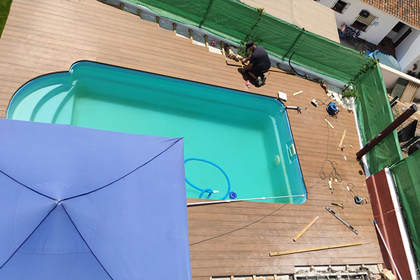 Piscina con tarima exterior sintética y césped artificial